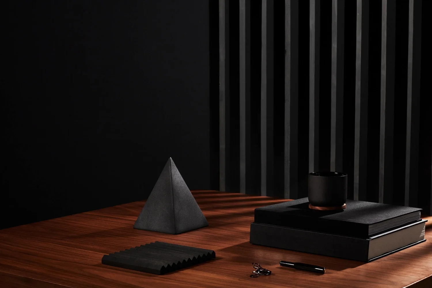 Geometric objects on a desk against a dark backdrop